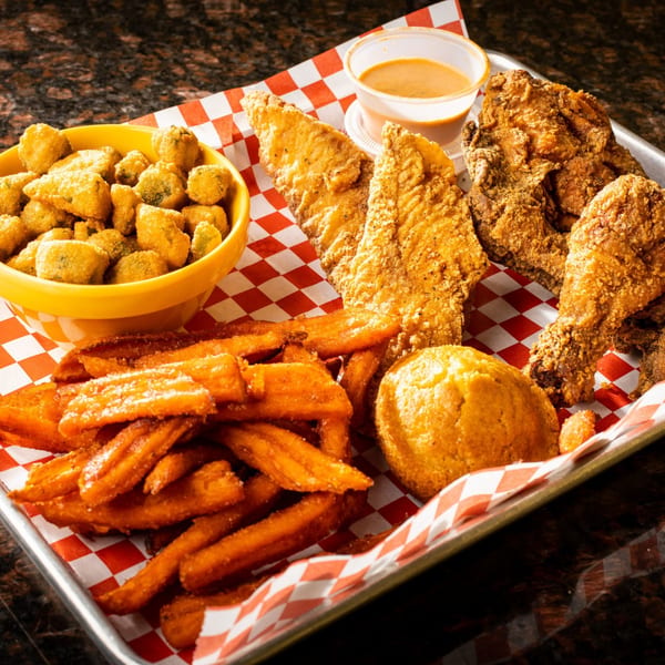 A tray of Sharon's Creole Kitchen fried catfish, chicken, okra, sweet potato fries, and cornbread.